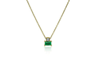 A 14k yellow gold solitaire pendant set with emerald and diamonds.